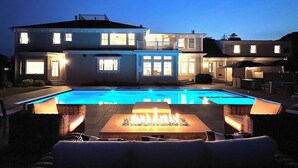 A two-story house with a swimming pool and outdoor seating area.
