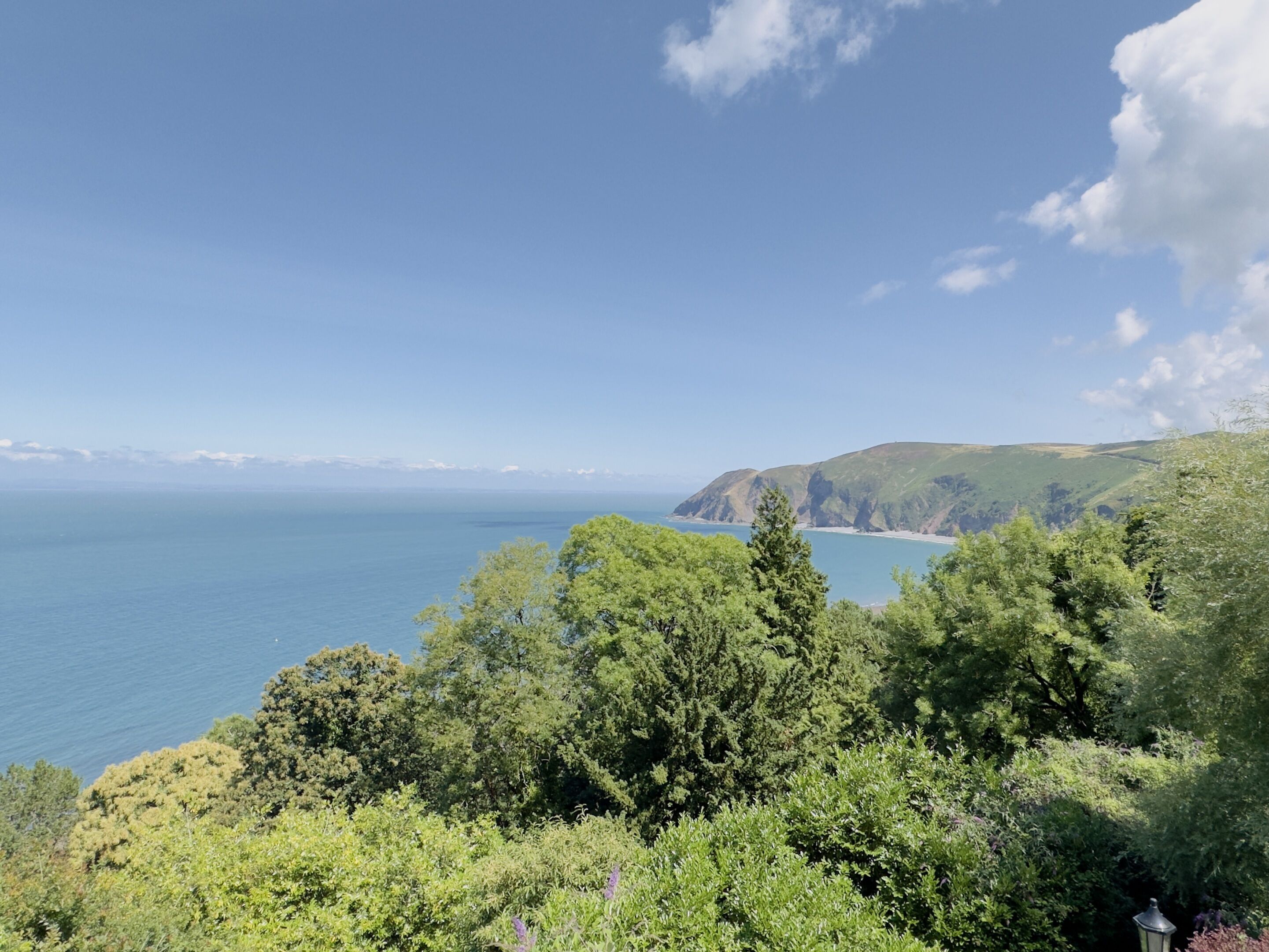 Paesaggio costiero con vista sul mare e sulle colline.