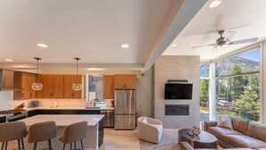 A modern kitchen with wooden cabinets, a central island, stainless steel appliances, pendant lighting, and a large window offering a mountain view. - Minutes from Frisco Main Street, 3 Balconies with Panoramic Mountain Views (Frisco)