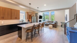 A modern kitchen with a large island, wooden cabinets, and a dining area with a sofa and table. - Minutes from Frisco Main Street, 3 Balconies with Panoramic Mountain Views (Frisco)
