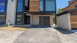 A modern two-story building with a combination of wood and glass facade, numbered 224E, featuring a driveway and a gravel area. - Minutes from Frisco Main Street, 3 Balconies with Panoramic Mountain Views (Frisco)