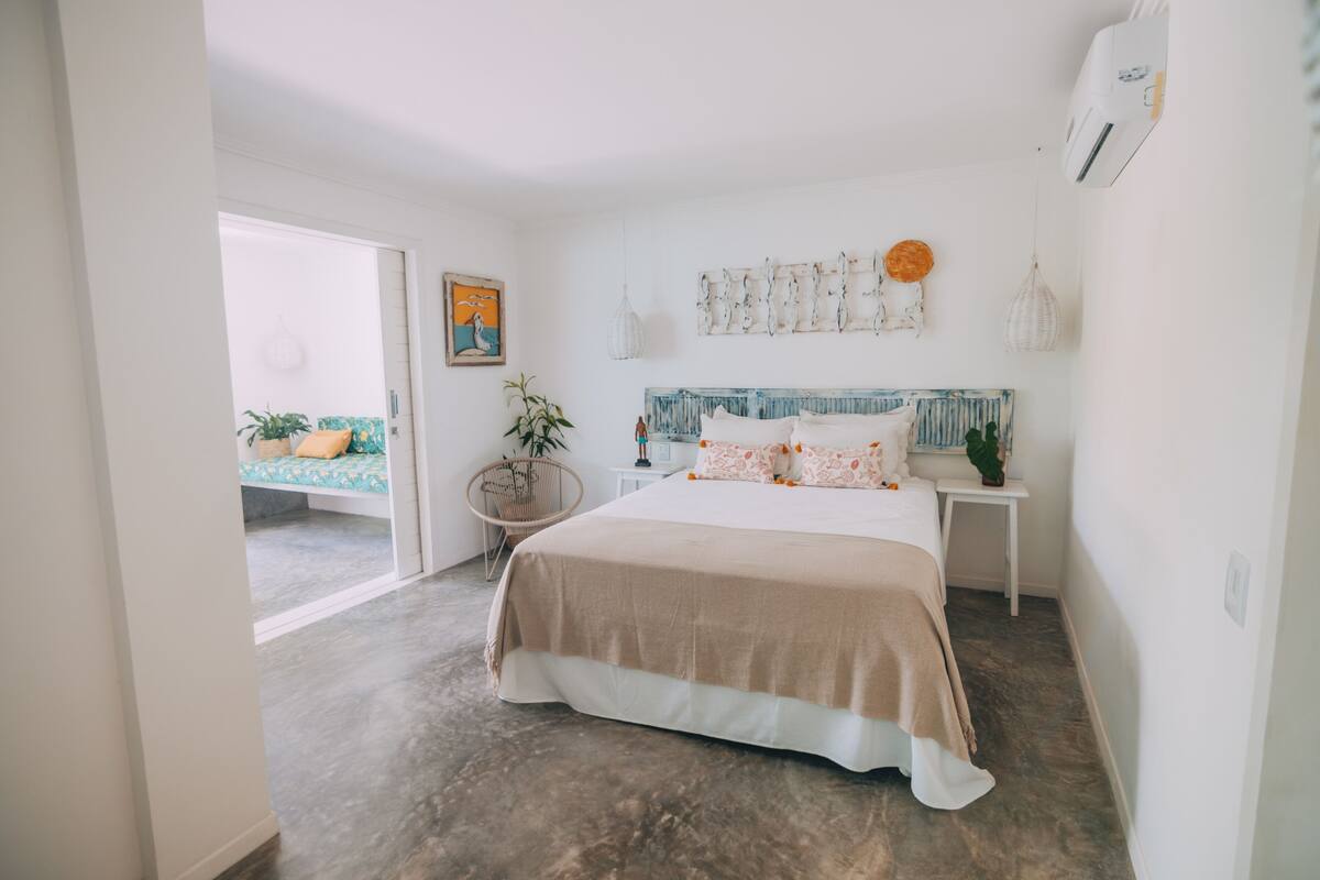Un dormitorio con una cama grande, una mesita de noche, una silla y vistas a un balcón.