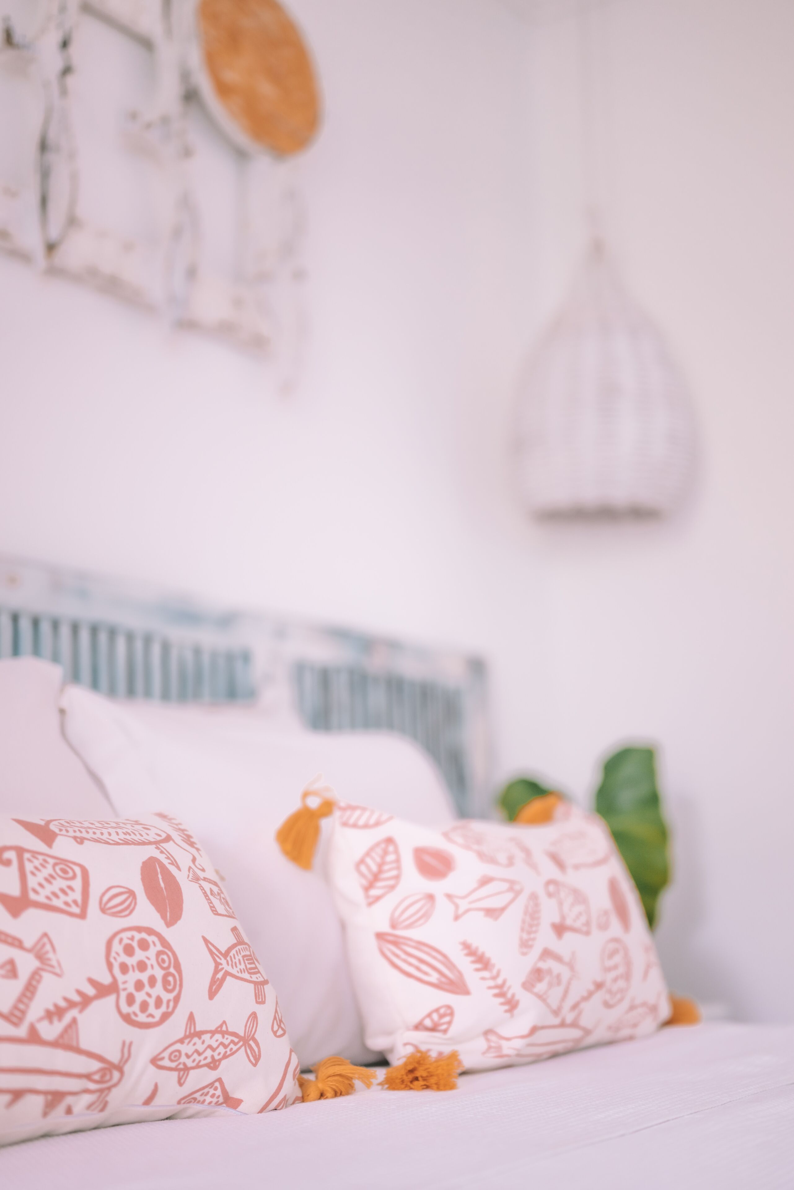 Een bed met gestreepte kussens en een hanglamp.