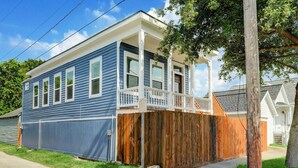 A two-story house with a front porch and a wooden fence.