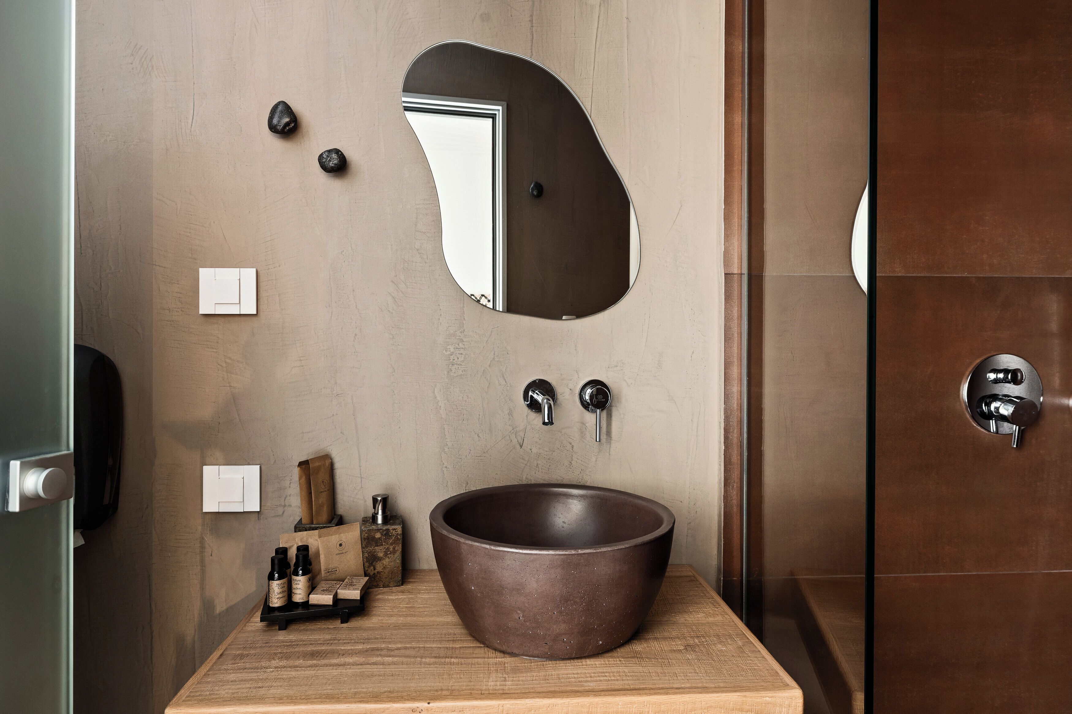 Een moderne badkamer met een grote wastafel, een spiegel en een houten aanrecht.