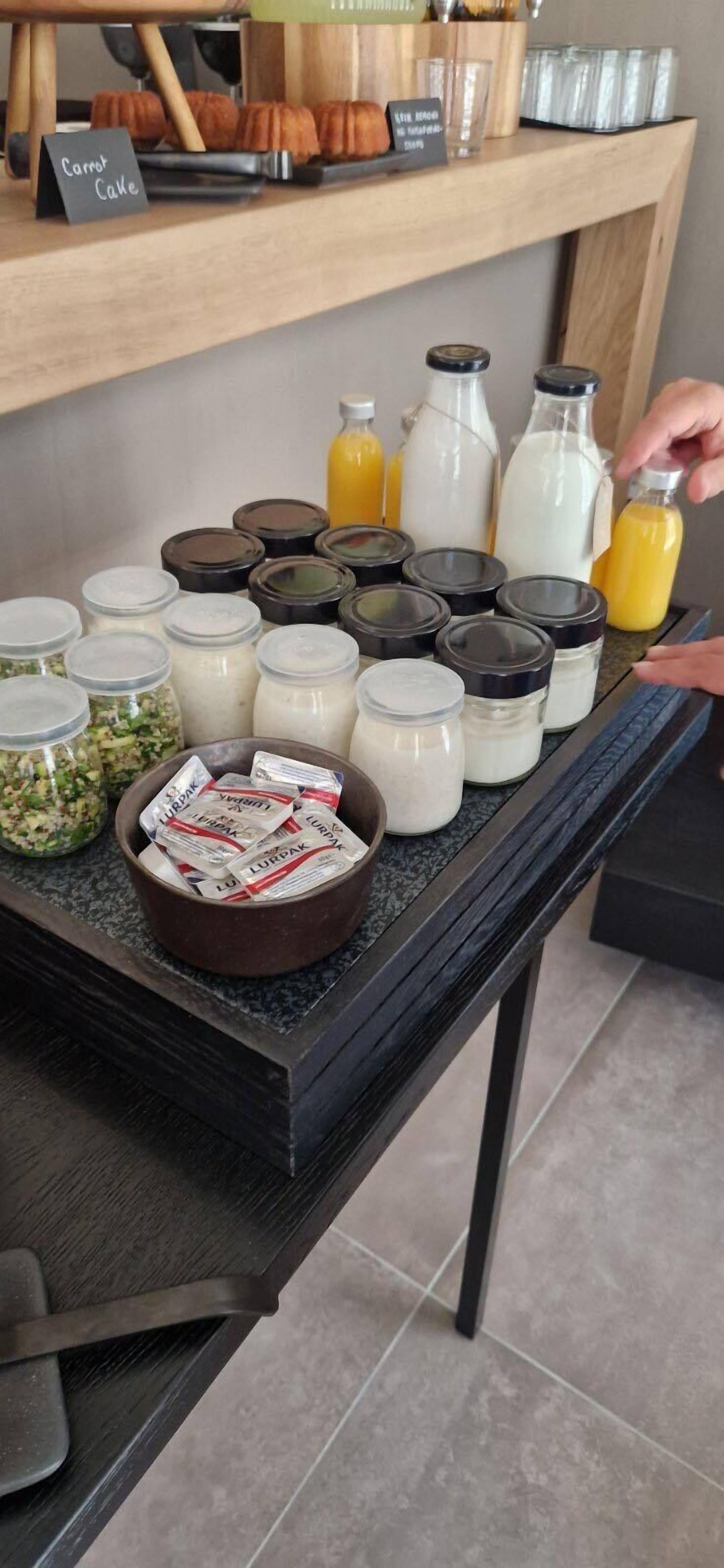 A breakfast buffet setup with various food items and condiments.