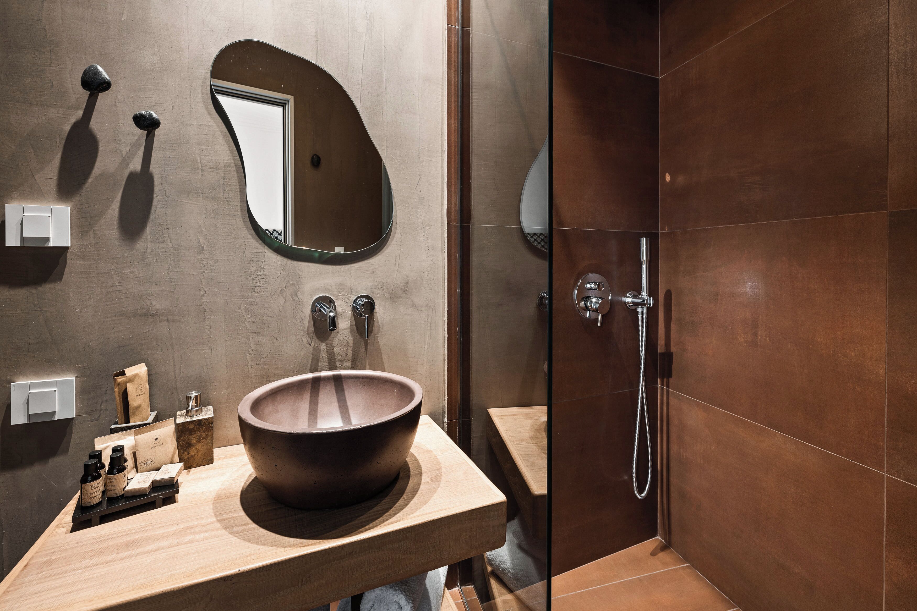 Une salle de bain moderne avec un grand lavabo en bois, un miroir et un espace douche.