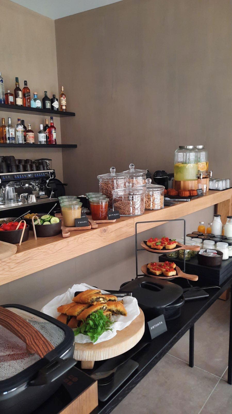 A buffet setup with various food items, beverages, and condiments.