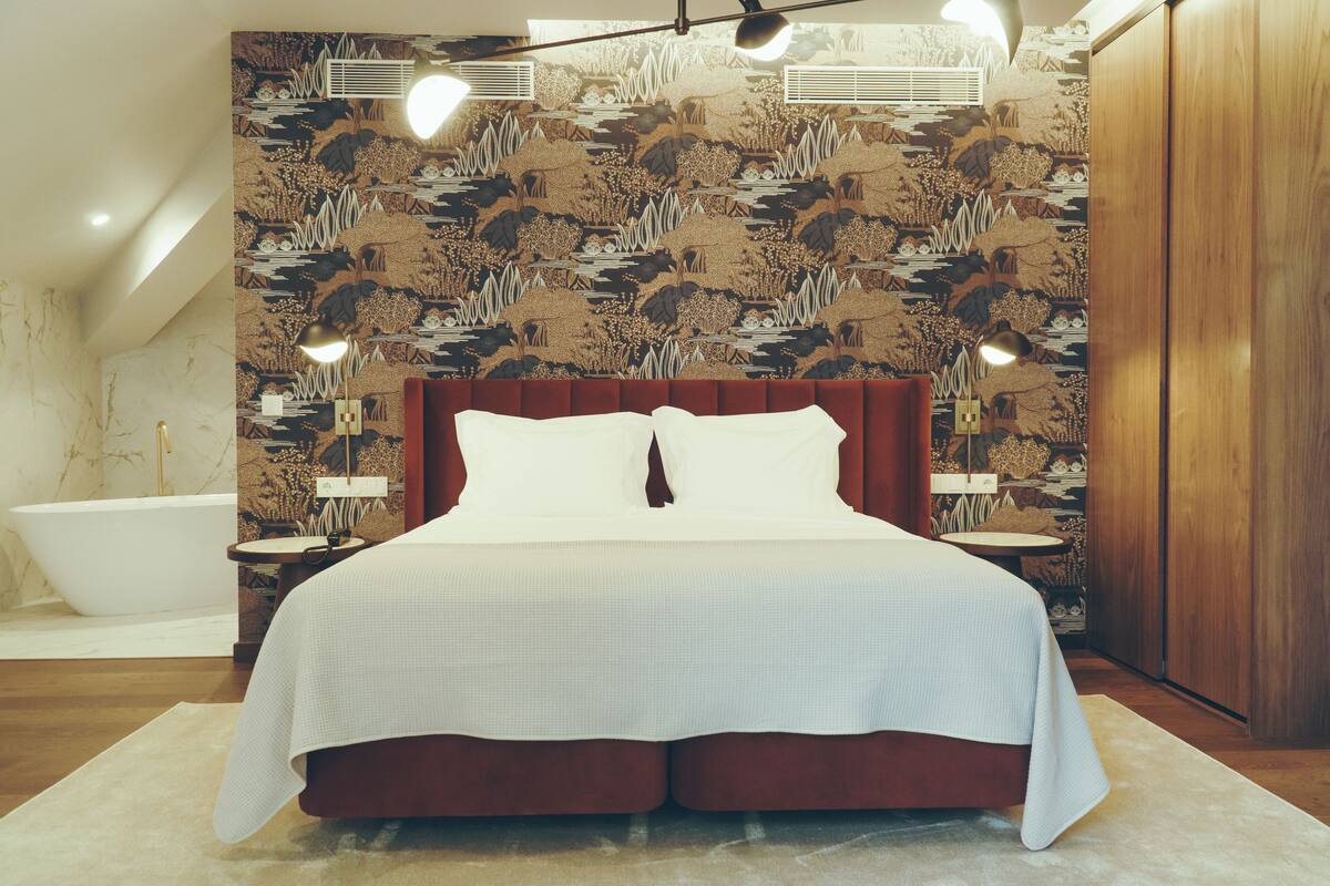 Un dormitorio con una cama grande, un armario de madera y una bañera.