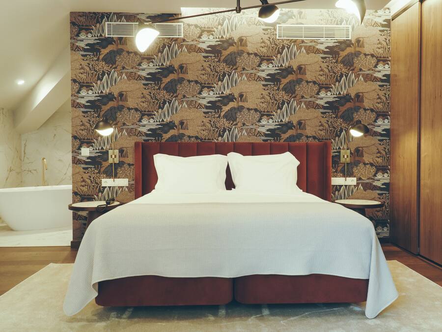 Ein Schlafzimmer mit einem großen Bett, einem Holzschrank und einer Badewanne.