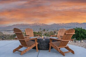 A seating arrangement with a fire pit and a view of mountains.