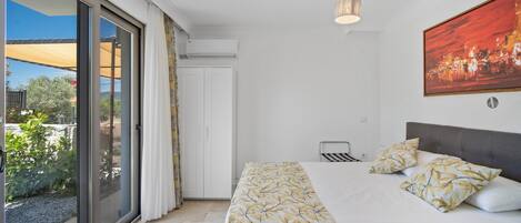Une chambre à coucher avec un lit, un luminaire au plafond, une fenêtre avec des rideaux et un tableau accroché au mur.