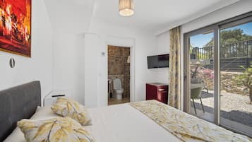 Un dormitorio con cama, televisor, un armario rojo y vistas al exterior.