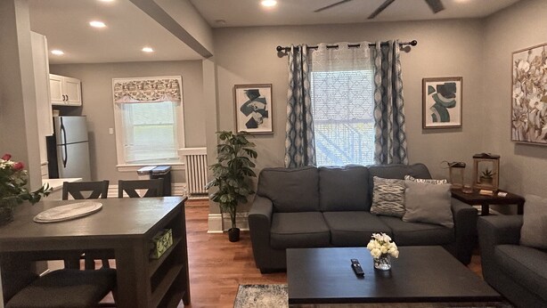 A living room with a sofa, coffee table, and dining area with chairs and a table.