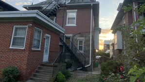 A two-story brick house with a central staircase and a small porch.