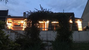 Ein Haus mit sichtbarer Treppe, die zum Eingang führt, umgeben von Grünpflanzen.