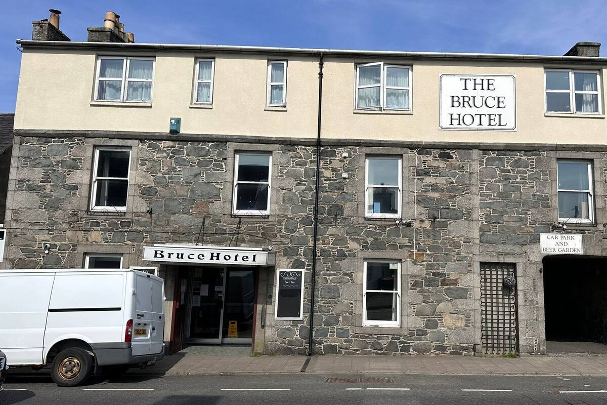 A two-story building with a sign reading "The Bruce Hotel" and "Car Park and Beer Garden" indicating a hotel with parking and a beer garden.