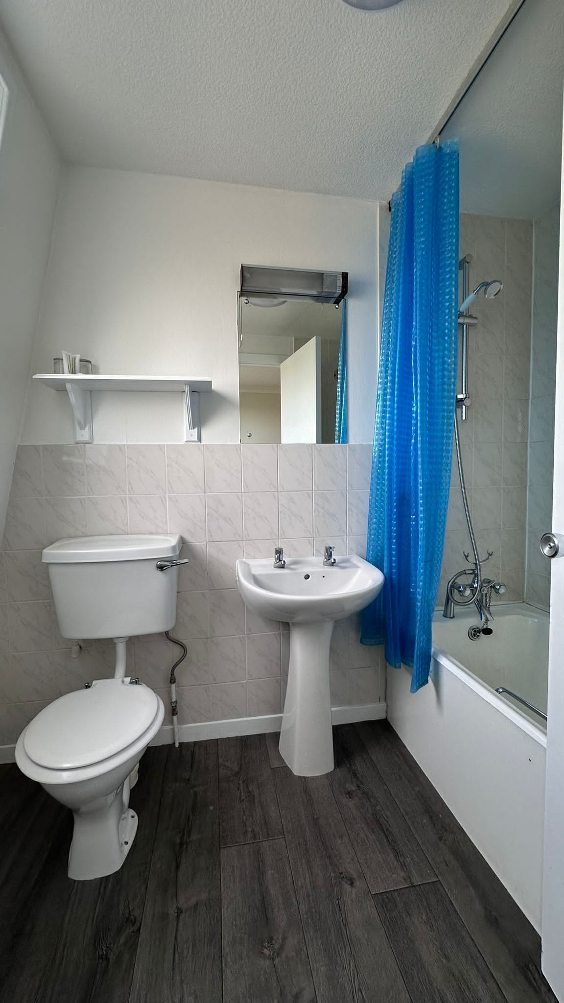 A bathroom with a toilet, sink, and bathtub.