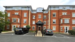 A multi-story residential building with a central entrance and a covered walkway. - Spacious Apartment, Near to NEC and City Centre.  (Solihull)
