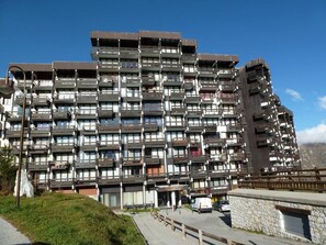 Ein mehrstöckiges Hotel mit Balkonen, einer Stein-Fassade und blauem Himmel.