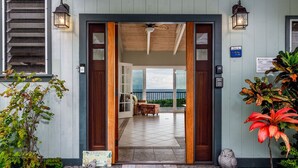 A wooden entrance with a welcome mat, a view of the interior, and a balcony with a view.