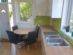 Enjoy meals in this kitchen with a round table and four chairs, adjacent to a window with a view of the surrounding greenery.