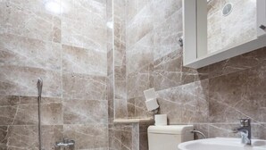 Ein Badezimmer mit Badewanne, Toilette und Waschbecken, ausgestattet mit modernen Armaturen.