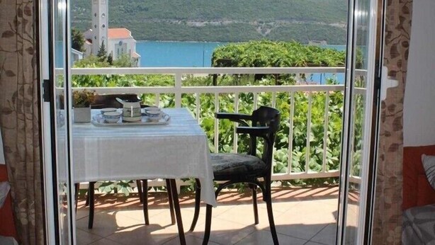 A room with a balcony overlooking a scenic view of a lake and mountains. - Apartmani Kata / Studio apartment 2 with Sea view (Neum)