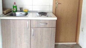 A small kitchen with a sink, a stove, and wooden cabinets. - Apartmani Kata / Studio apartment 3 on the ground floor (Neum)