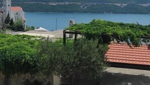 A coastal view with a church, a clear sky, and a body of water. - Apartmani Kata / Studio apartment 3 on the ground floor (Neum)