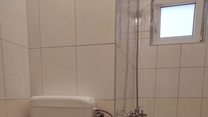 A bathroom with a toilet, a shower enclosure, and a bathtub.