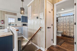Stylish interior with a wooden panel wall, white door, and staircase.