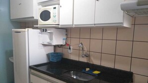 A kitchen with a microwave, refrigerator, sink, and cabinets. - Diroma International Resort - Caldas Novas Goias (Chácara Roma Caldas Novas)