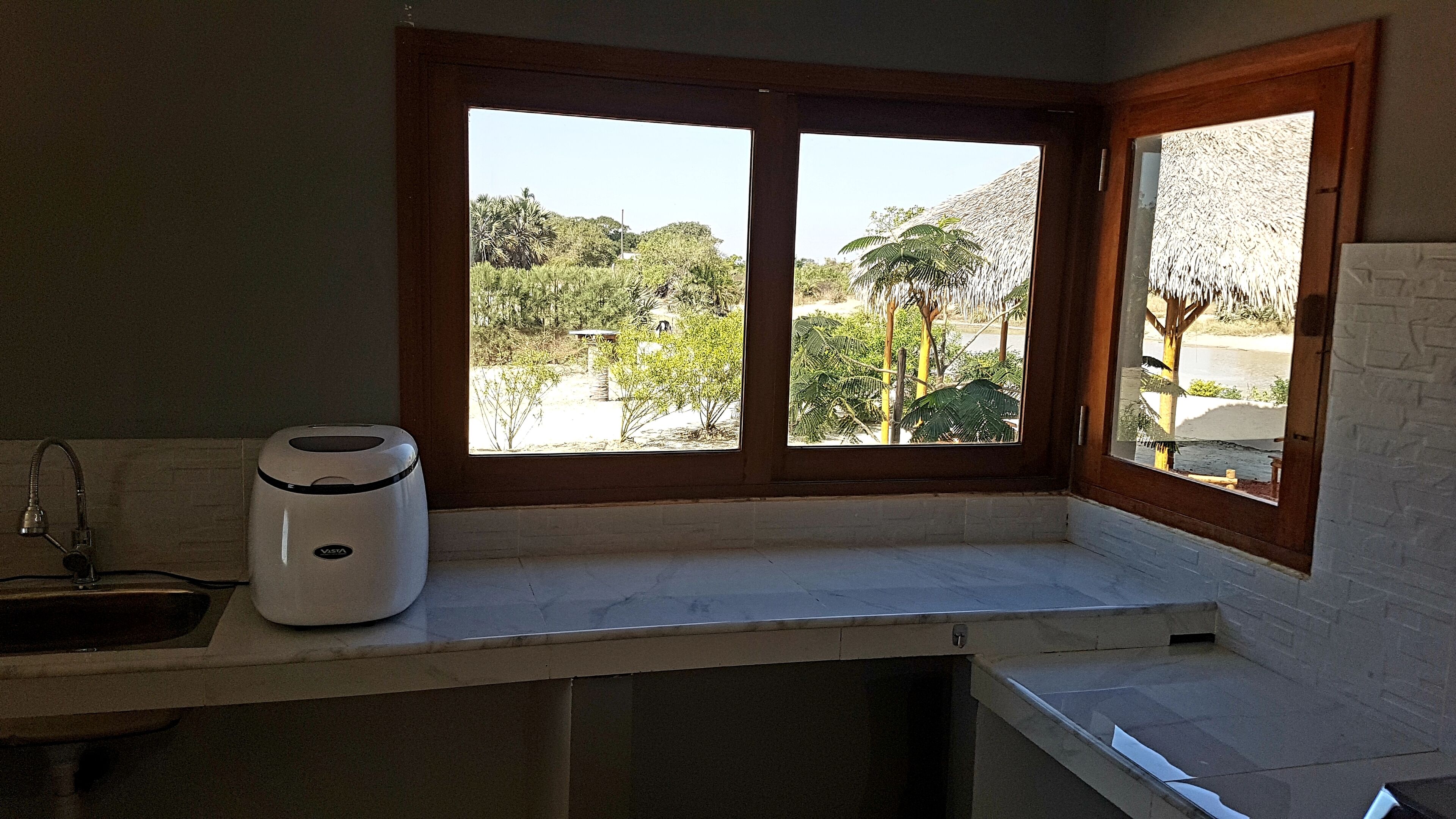 Eine Küche mit Fensterblick auf einen Garten.