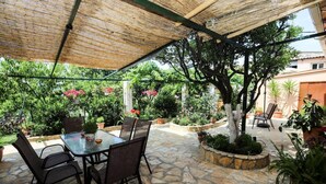 An outdoor patio with a stone floor, a table with chairs, and various potted plants. - Garden House Kastellani -corfu Greece Free Wi-fi (Corfu)