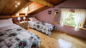 A cozy attic bedroom with two beds, wooden beams, a window with curtains, and a small picture on the wall. - Garden House Kastellani -corfu Greece Free Wi-fi (Corfu)