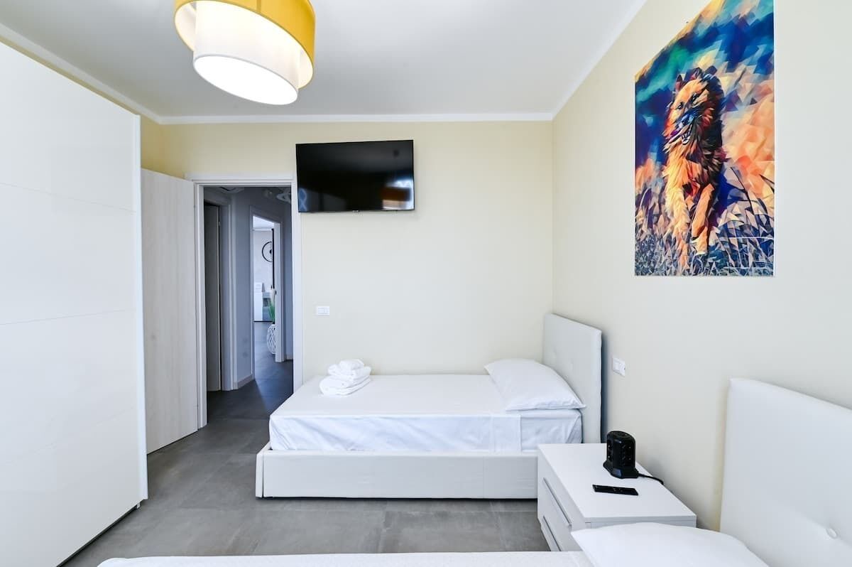 A modern bedroom with a bed, bedside table, and a painting on the wall.