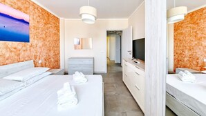 A modern hotel room with two beds, a TV, a mirror, and a painting on the wall. - The Bridge - Peschiera Holiday (Peschiera del Garda)