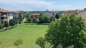 A residential area with multiple buildings, a grassy field, and trees. - The Bridge - Peschiera Holiday (Peschiera del Garda)