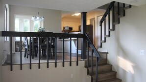 Een trap met een donkere balustrade die uitkomt op een plateau.