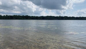 Een helder meer, omringd door bebost gebied.