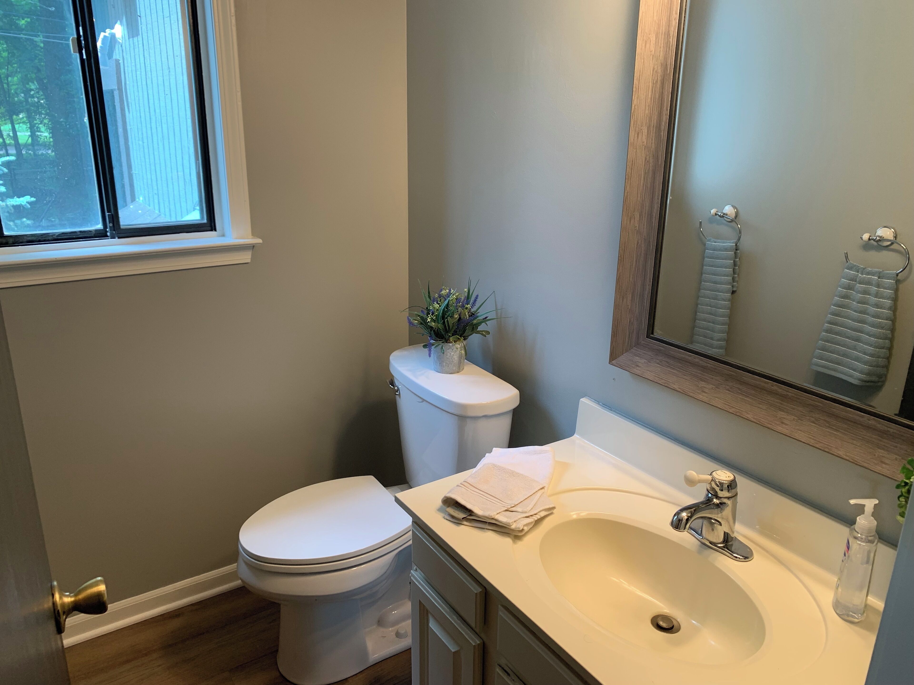Un baño con inodoro, lavabo y ventana.