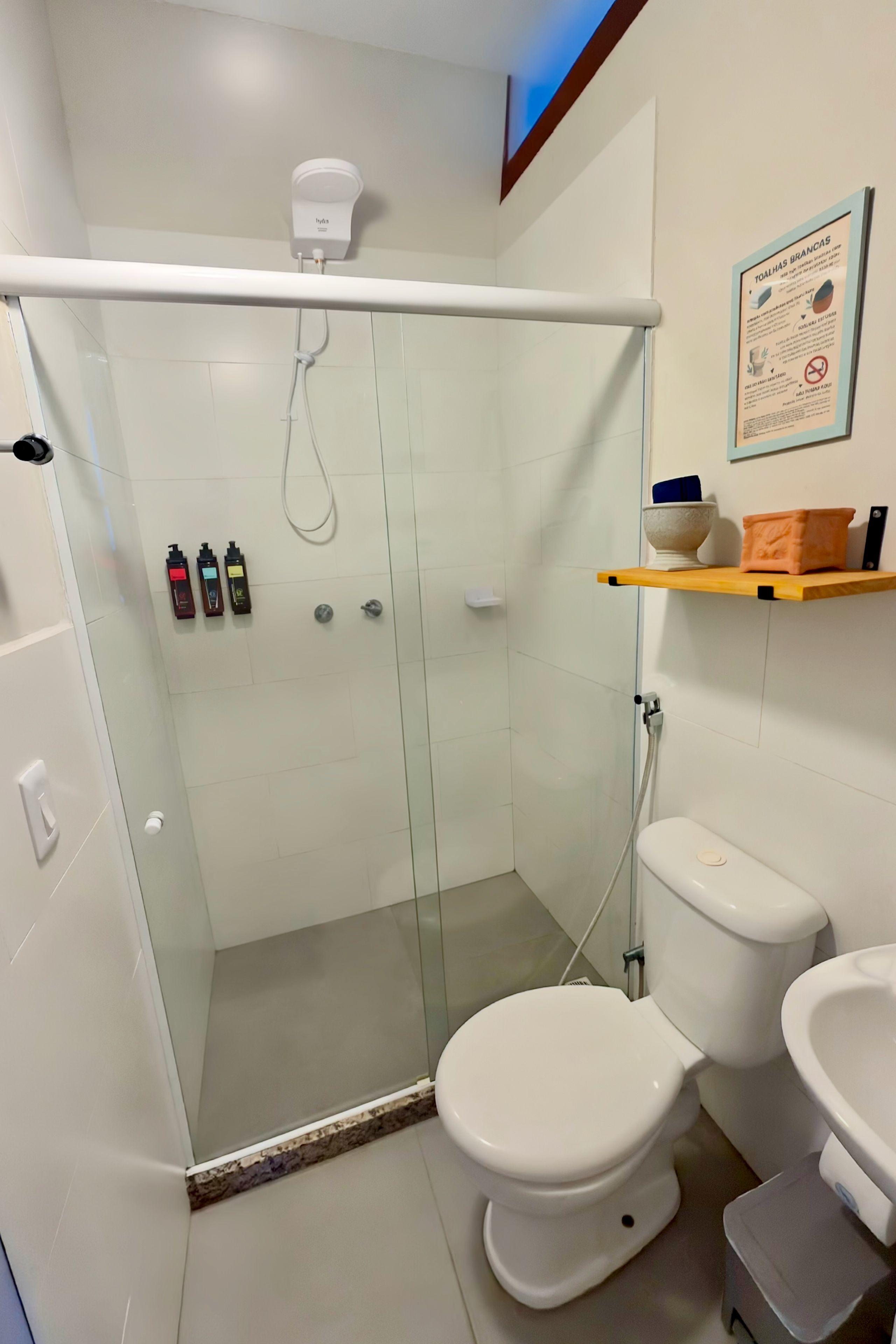 Un baño moderno con ducha envuelta en vidrio, inodoro y lavamanos.