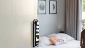 A hotel room with a bed, a ceiling fan, and a door with a handle.