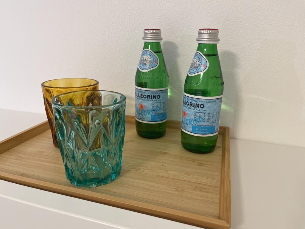 A tray with a glass and two bottles of Pellegrino water.
