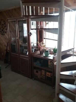 Cozy retreat with high ceilings, wooden paneling, and a large window.