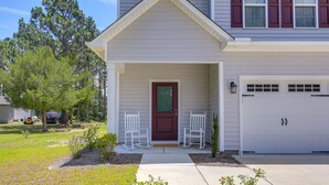 A two-story house with a front porch, a garage, and a well-maintained lawn.