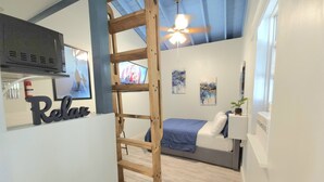 A bedroom with a bunk bed, a wooden ladder, a ceiling fan, and artwork on the walls. - Charming Studio Loft In Hollywood Beach, Free Parking (Hollywood)