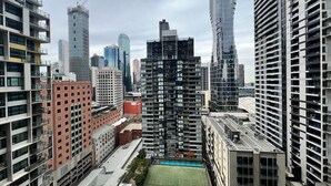 A high-rise urban area with multiple buildings, including a prominent skyscraper and several mid-rise structures. - Stunning City View 2BR in CBD by Readyset Apartments (Melbourne)