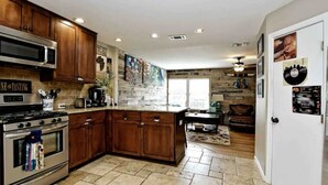 Una cocina con armarios de madera, una estufa de acero inoxidable y una isla grande.
